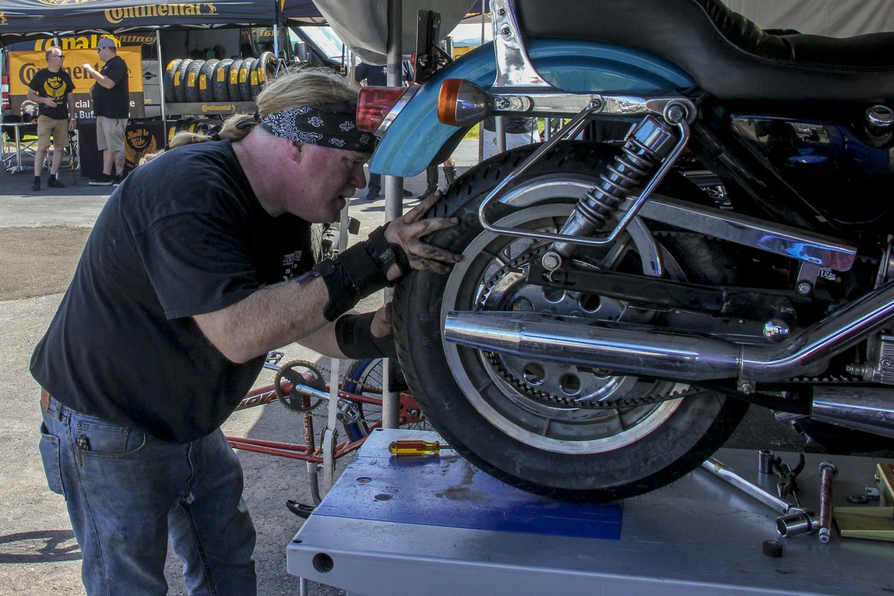 Biker Wrenching on a motorcycle at the Sturgis Buffalo Chip Garage
